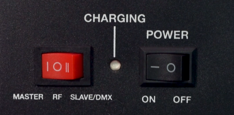 A black device control panel showing a red three-position mode switch on the left labeled MASTER(selected), RF, and SLAVE/DMX; a central LED indicator labeled CHARGING; and a black POWER switch on the right labeled ON and OFF.